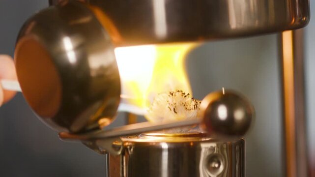 lighting the wick of a Victorian era coffee maker
