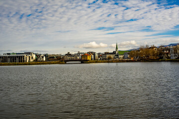 Obraz premium Reykjavik cityscape across Tjornin lake with Frikirkjan church and colorful houses, Iceland