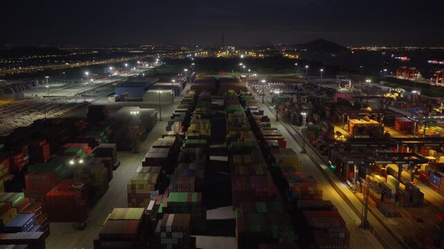 Night panorama of container terminal with cranes lights and freight lanes
