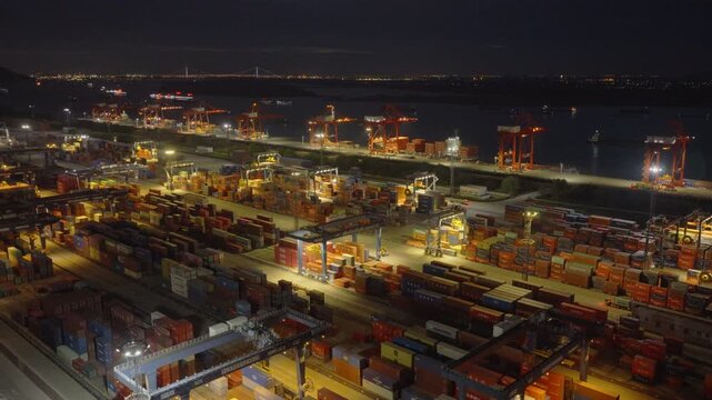 Illuminated container port and vehicle yard at night with industrial harbor lights