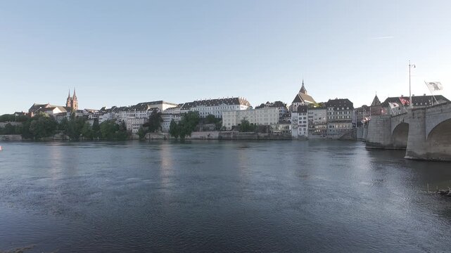 Static shot of Basel old town skyline with M&uuml;nster cathedral, Mittlere Br&uuml;cke bridge and Rhine river at sunset in Switzerland