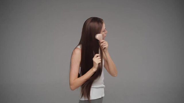 Side view of a model with perfectly straight hair in a studio. Hair brushing