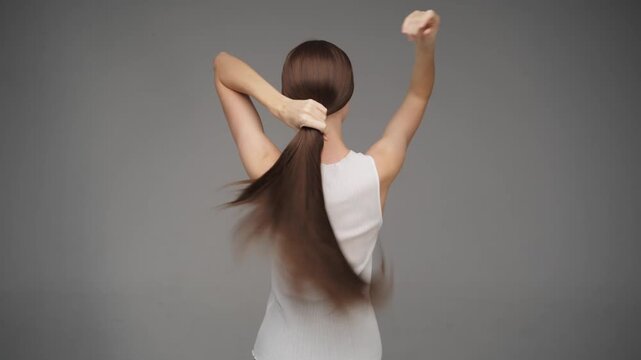 Woman Flipping Long Straight Brown Hair from Back View