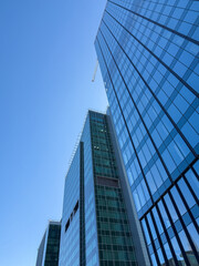 Obraz premium Skyscrapers in the city and blue sky background low angle view. Minimalistic architecture made of glass, tall buildings, business and finance, construction industry