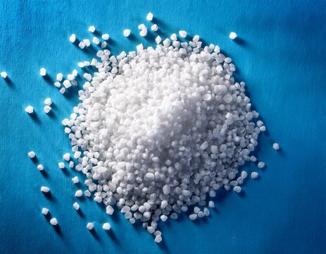 raw polymer granules in industrial plastic production highlighted on a blue background
