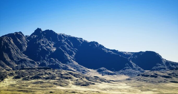 sunlit rocky mountains under clear sky, ideal geological survey site with rugged ridges, scree slopes and broad dry plateau in foreground drone mapping
