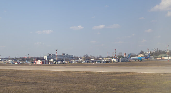 Distant view of the Chisinau International Airport airfield featuring FlyOne aircraft and airport infrastructure - - Chisinau, Moldova March 16 2026