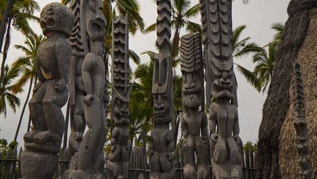 Stone tikis underneath the palm trees of Hawaii