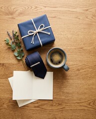 Fototapeta premium Gift box, tie, coffee cup, and blank cards on wooden table 