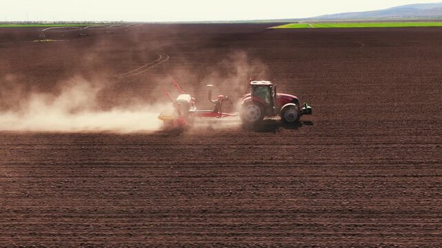 Cinematic Lateral Dolly Shot of Tractor Sowing Seeds in Agricultural Field