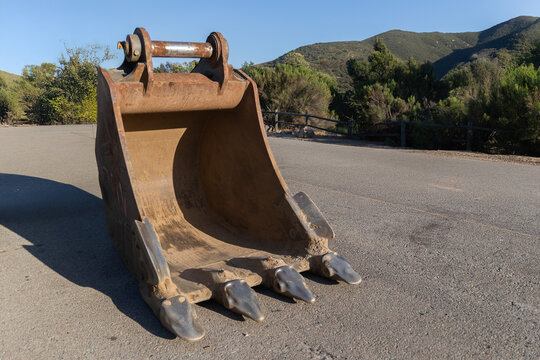 A close-up of a digger front loader
