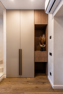 Modern hallway built-in wardrobe with wooden niche and decor