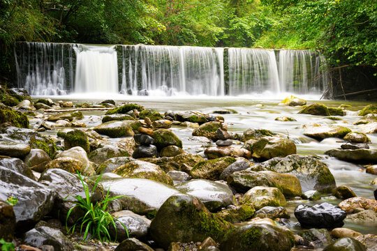 Serene Forest Waterfall Cascading Over Mossy River Rocks
