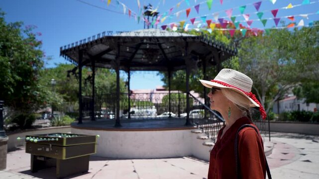 Mature woman takes a stroll in Santa Rosalia, Baja California. She visits local attractions and enjoys the vibrant atmosphere in the town.