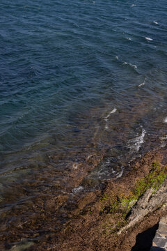 deep turquoise waves crashing onto rocky shore