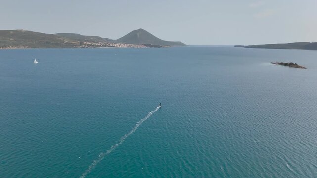 Aerial View of Windsurfer Riding Across Blue Water in Navarino Bay with Greek Coastline, Sailboats and Mountain Landscape in Peloponnese, Greece