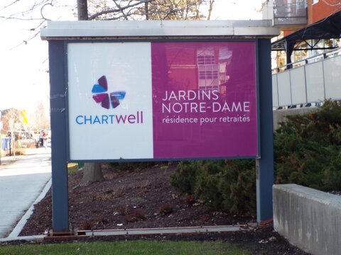 Gatineau, Quebec, Canada &ndash; April 18, 2026: A ground sign for "Chartwell Jardins Notre-Dame", a retirement residence, is displayed next to a sidewalk on Bd Gr&eacute;ber.