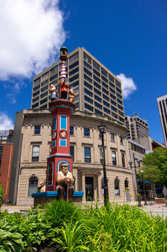Saint John, New Brunswick, Canada&mdash;June 19, 2018; A colorful public art sculpture column rises above landscaped greenery in downtown Saint John