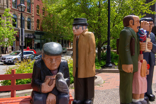 Saint John, New Brunswick, Canada&mdash;June 19, 2018; Large carved public sculptures stand in a downtown plaza surrounded by historic buildings and tree