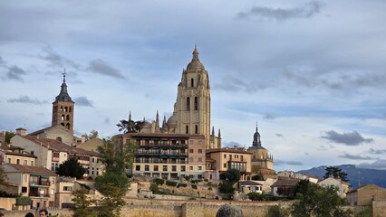 Obraz premium The majestic Segovia Cathedral towering over historic city buildings in Spain.