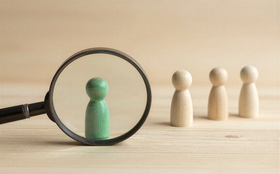 Magnifying glass highlights a green figure while others stand in the