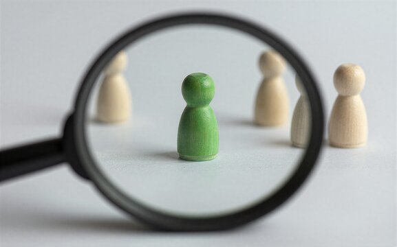 Magnifying glass highlights one green pegman among beige peers