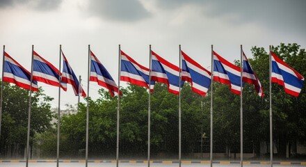 Obraz premium Thailands National Flags Displayed in a Row Against Cloudy Sky.