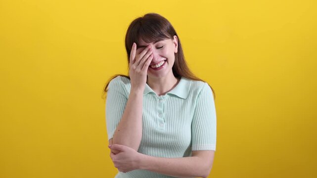 Happy woman laughing at joke on yellow background