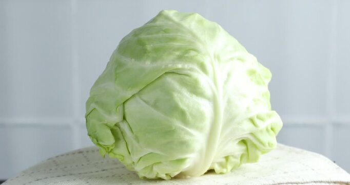 One fresh ripe cabbage on table, rotating