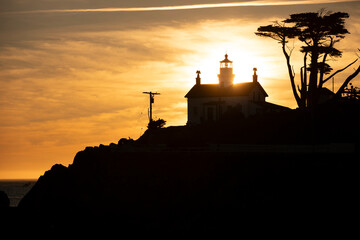 Sunset light illuminates a historic lighthouse and beach along the Pacific Ocean in Crescent City, California, USA. © Matt Gush
