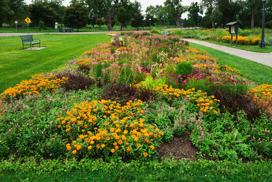 Close up of a large garden bed at Washington Park in Denver, Colorado, filled with a variety of colorful plants and flowers designed to attract pollinators.