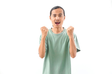 Naklejka premium young handsome Indonesian, Asian man in green shirt positive expression, joyful and exciting isolated on white background. Happy adorable glad man rejoices success