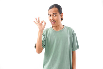 young handsome Indonesian, Asian man in green shirt OK or approved sign with fingers and gesture...