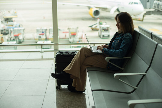 Businesswoman working on her computer with the runway in the background.