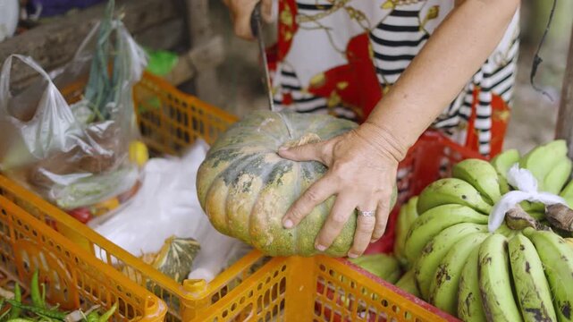 Vegetable Vendor Cutting Yellow Squash at Street Market Stall