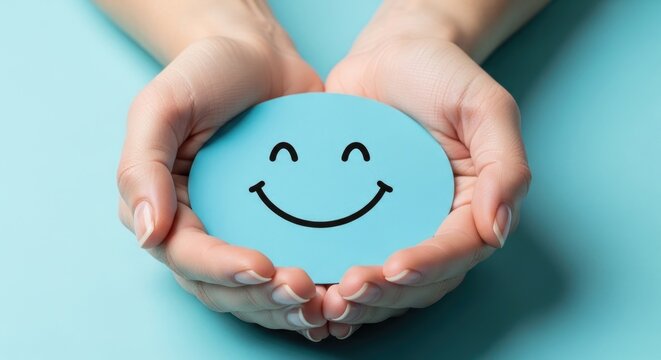Hands holding a blue circular with a smiling face on a light blue background