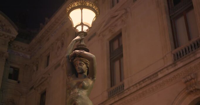 Bronze Sculpture Caryatid Lamp Post Outside The Palais Garnier In Paris, France. Low Angle Shot