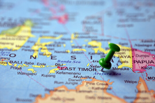 Green Push Pin Marking East Timor on Blurred World Map Macro Close Up Travel Concept