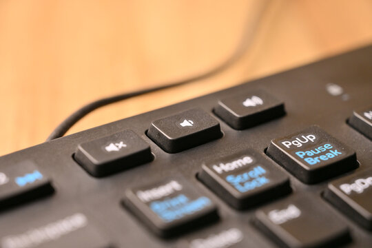 Black Computer Keyboard Macro Shot Highlighting Volume Increase Key with Soft Blurred Background Angled Top View