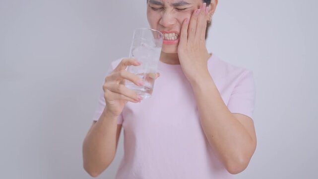 woman having toothache and pain after drink ice water for concept of Teeth Sensitive to Cold, Tooth Decay and Gum Disease, Grinding Teeth and Stress, Exposed Nerve Roots, Crack and Receding