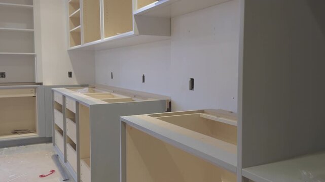 Modern Kitchen Cabinets Installation in Progress, Unfinished Light Wood and Gray Cabinetry