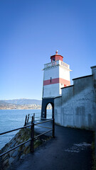 Fototapeta premium Brockton Point Lighthouse in Stanley Park with North Vancouver skyline