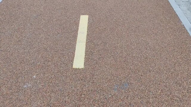 Bicycle symbol painted on gravel surface showing a bike lane concept