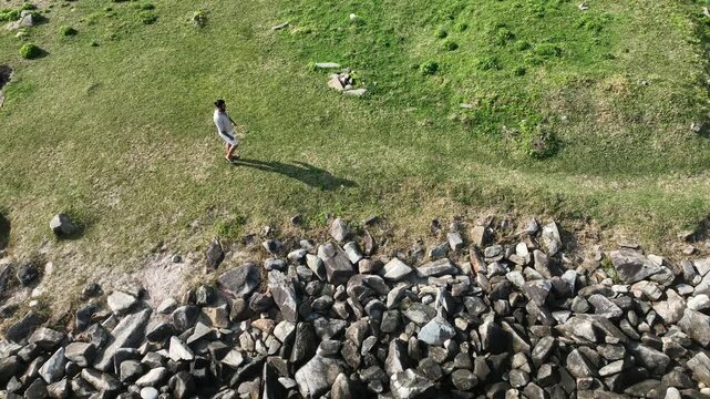 Ponta das Campanhas, Armacao in Florianopolis. A man walks across the island among the rocks. Aerial view.