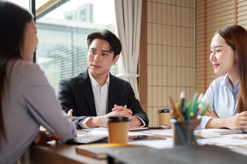 Fototapeta premium Asian business team collaborating in modern office meeting