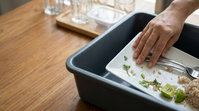 Dining table messy dish plate fork hand kitchen cleanup food waste. Messy dining table mess scrap, clutter, chaos cleanup waste dirty