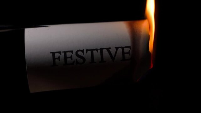 Burning paper with word festive on black background. Conceptual shot of ruined celebration with fire flame