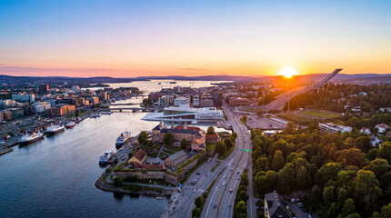 Obraz premium Panoramic aerial view of Oslo, Norway at sunset, showcasing the cityscape, harbor, and surrounding nature.