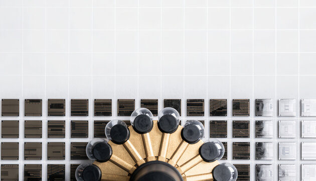 Top down photograph of industrial machine panel with metal grid and circular mechanism