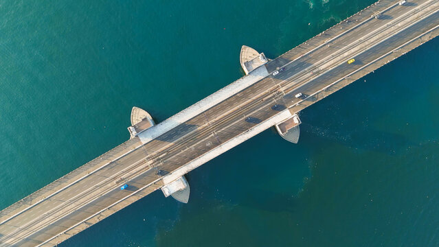 Istanbul, Turkey. Galata Bridge, a steel bascule span with tram tracks and vehicle lanes, top down aerial view over the deep turquoise waters of the Golden Horn at morning sunlight